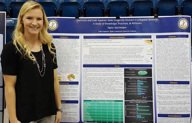 Taylor Steinhelper standing in front of her senior research poster